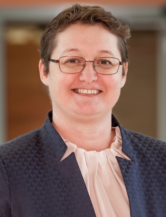 Portrait von Monika Skiba vor einem dunklen Hintergrund. Sie blickt freundlich in die Kamera.